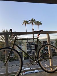 Bicycle by railing against clear sky