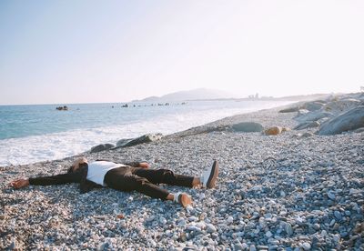 Young man lying on shore of beach