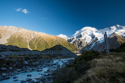 Scenic view of snowcapped mountains against blue sky