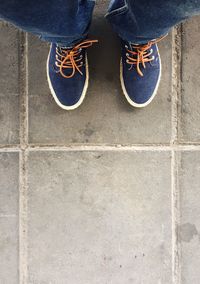 Low section of man standing on tiled floor