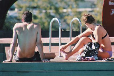 People sitting at poolside