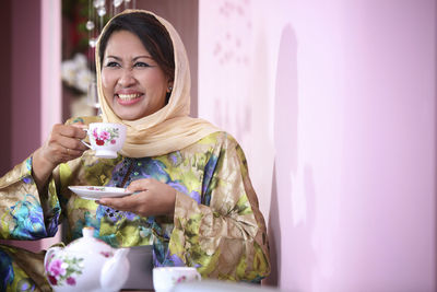 Woman having coffee while sitting at home