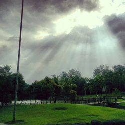 Scenic view of grassy field against cloudy sky