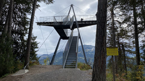 View of bridge by trees against sky