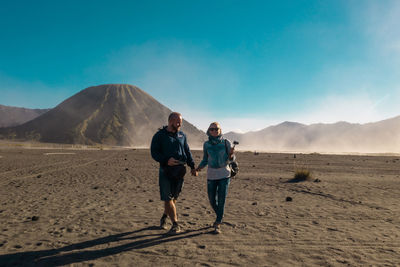 Rear view of men walking on desert