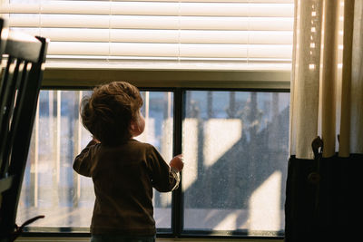 Boy looking through window