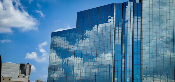 Low angle view of modern building against blue sky