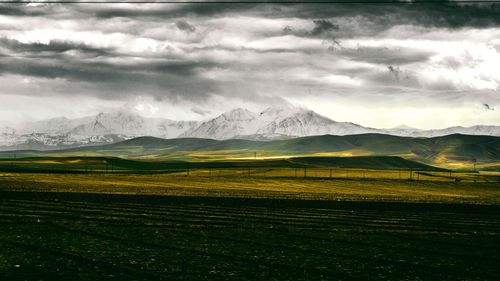 Scenic view of mountains against cloudy sky