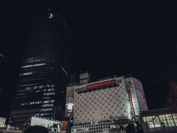 Low angle view of illuminated buildings against sky at night