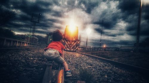 Man standing by train on railroad track against sky