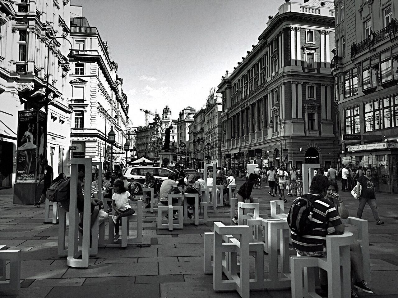 PEOPLE ON CITY STREET AGAINST SKY