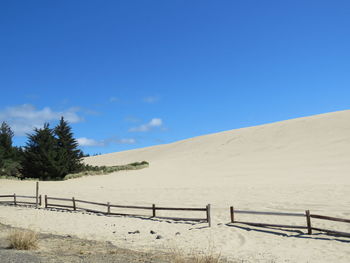 Scenic view of desert against clear blue sky