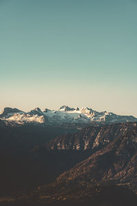 Aerial view of snowcapped mountains against clear sky