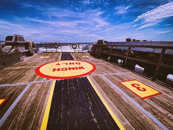 Information sign on road against sky