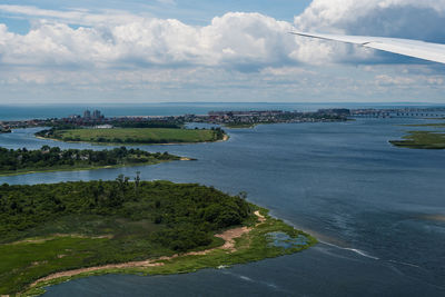 High angle view of city by sea against sky