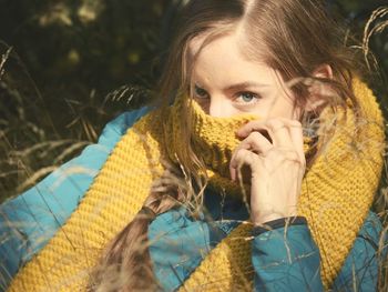 Portrait of young woman covering face with scarf