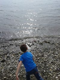 Rear view of boy standing on beach