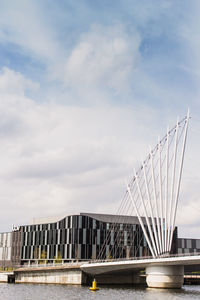 Bridge over river against sky in city