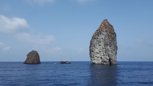 Scenic view of rocks in sea against sky