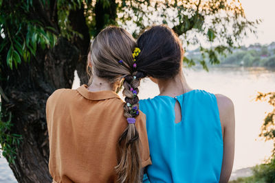 Rear view of women standing against plants