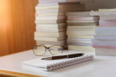 Close-up of pen on open blank book at table