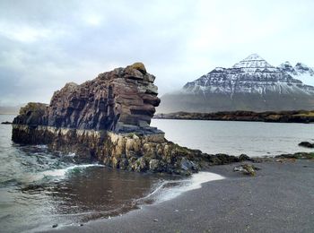 Rock formation on beach against sky
