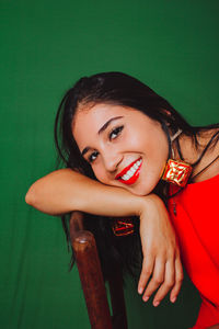 Beautiful woman in red dress smiling. wearing christmas earrings.