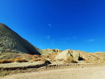 Scenic view of desert against clear blue sky