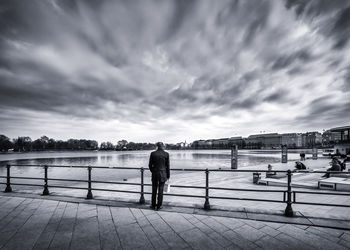 Rear view of man standing on jetty