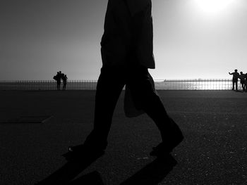 Silhouette people standing on street against clear sky