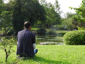 Rear view of man sitting on grass