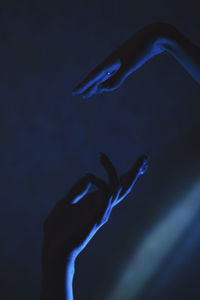 Cropped hands of woman gesturing in darkroom