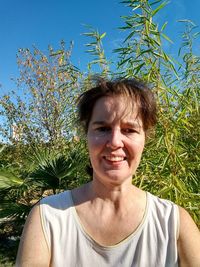 Portrait of smiling woman against plants