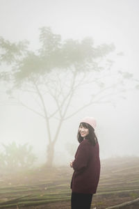 Side view of young woman standing on field