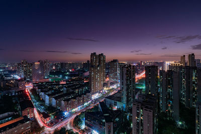 Illuminated cityscape against sky at night