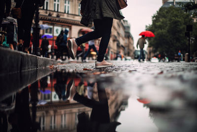 Low section of people crossing street in city