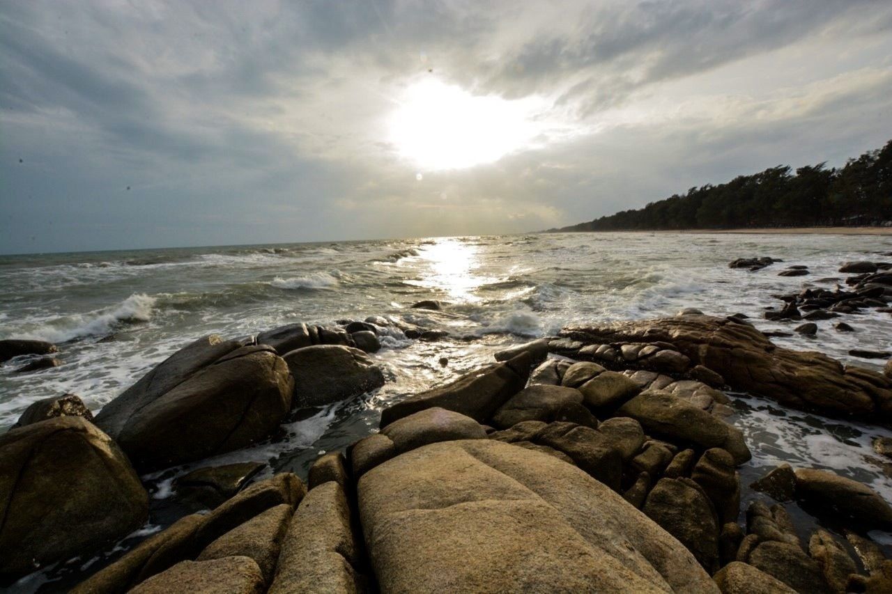 sea, water, sky, beach, tranquil scene, shore, scenics, tranquility, rock - object, horizon over water, beauty in nature, sun, cloud - sky, nature, sunlight, sunbeam, idyllic, stone - object, cloud, wave