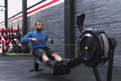 Athlete using rowing machine in gym