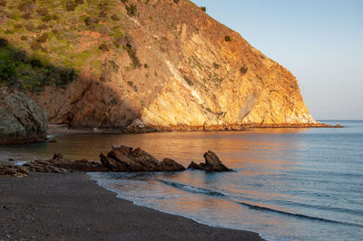 Scenic view of rock formation in sea against sky