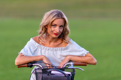 Portrait of woman with bicycle in background