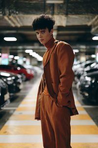 Side view of young man standing in city