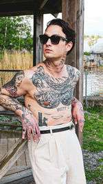 Portrait of young man wearing sunglasses standing outdoors