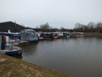 Boats moored in lake against clear sky