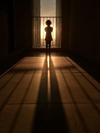 Rear view of silhouette child standing in corridor