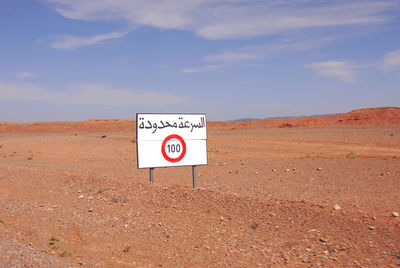 Information sign on road against sky