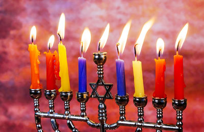 Close-up of lit candles on stick holder