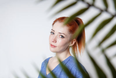 Portrait of young woman against wall