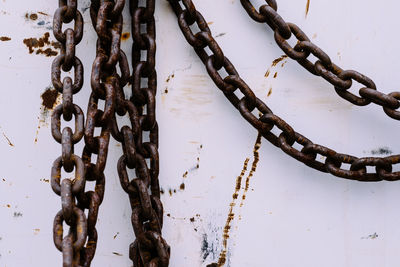 Close-up of rusty metallic chains on wall