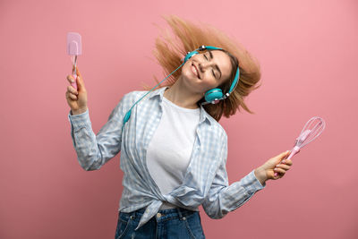 Young woman wearing mask against gray background