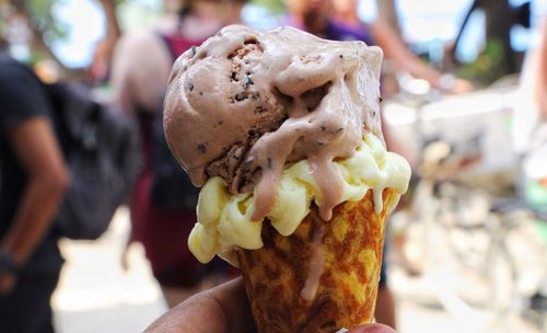 Close-up of hand holding melting ice cream